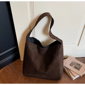 Dettaglio di borsa tote minimalista marrone scuro in finta pelle scamosciata morbida