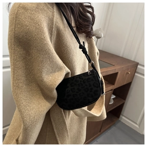 Détail du sac croissant imprimé léopard noir avec bandoulière nouée et finitions argentées