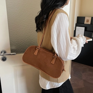 Minimalist brown suede shoulder bag with gold hardware and a vintage aesthetic design