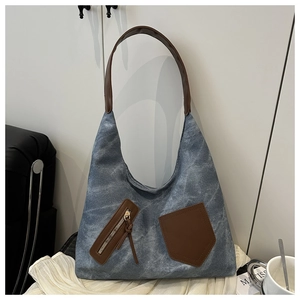 Detail of vintage blue canvas hobo bag with brown leather accents and side zip pocket