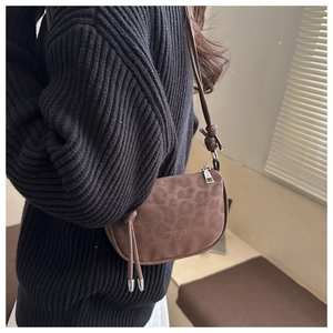 Gros plan détaillé du sac à bandoulière en cuir marron à motif léopard avec embossage