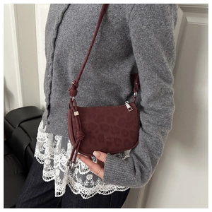 Détail du sac bandoulière bordeaux avec texture léopard subtile et bandoulière à nœud