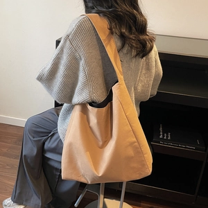 Grande borsa tote minimalista in tela marrone da donna con un outfit casual elegante