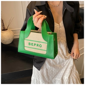 Detail of green and beige leather canvas tote bag with BEPRO lettering and metal hooks