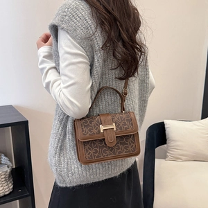 Brown monogram crossbody bag with retro GK pattern shown on a model in a home setting