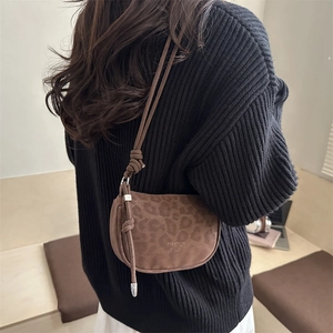 Sac croissant léopard marron avec bandoulière à nœud et logo sur un pull en maille noir