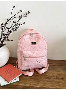 Pink fashion backpack with silver star patterns and metal logo on the front pocket
