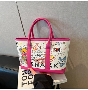 Detail of colorful graffiti patterns and pink leather trim on the fashion tote bag