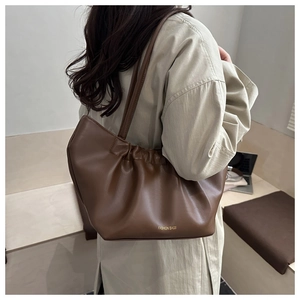 Détail d'un sac cabas plissé marron foncé avec inscription dorée FASHION BAGS pour femme