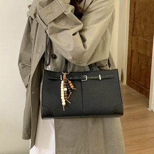 Minimalist black tote bag with twill texture and decorative bead tassel accessory
