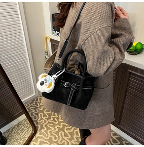 Détail du sac bandoulière noir avec garniture argentée et breloque koala blanc