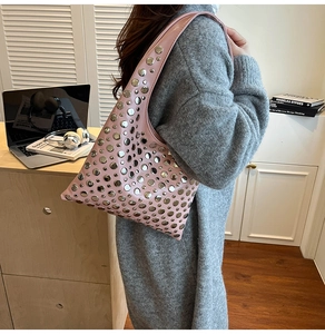 Détail du sac porté épaule demi-lune rose avec rivets argentés porté par un mannequin