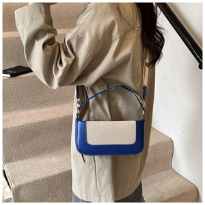 Detail of color-block crossbody bag on a model wearing a beige trench coat