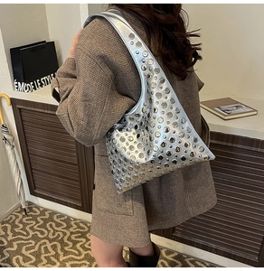 Détail du sac hobo argenté à rivets avec finition métallique porté à l'épaule au quotidien