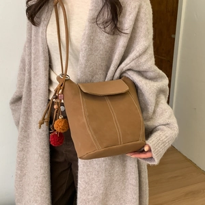 Bolso tipo cubo en gamuza color camello oscuro con dijes y correa de hombro para mujer