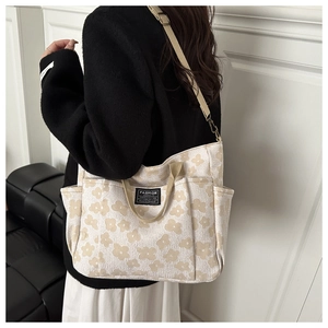 Detail of floral canvas tote bag with adjustable shoulder strap and fashion label
