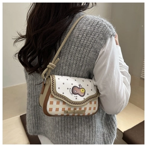 Detail of crossbody bag featuring cartoon apple patch, orange gingham and bow decoration