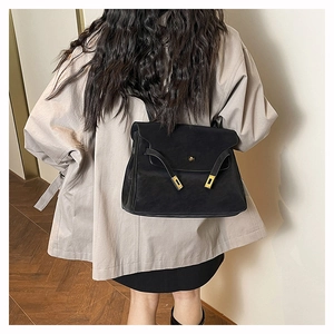 Detailed back view of a black matte leather shoulder bag with gold twist lock and side straps