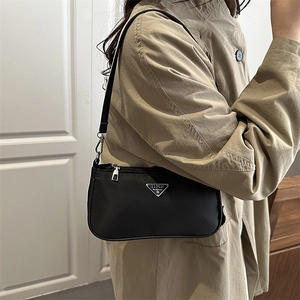 Minimalist black nylon underarm bag with silver triangle logo and zipper closure