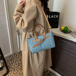 Retro light blue denim handbag with brown leather straps shown at a 45-degree angle