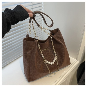 Detail of coffee leopard print tote bag with gold chain and white pearl flower charm