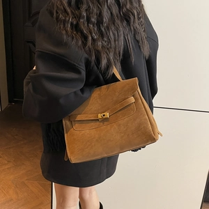 Brown vintage large suede briefcase bag with golden clasp closure on model shoulder