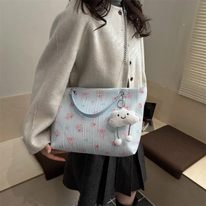 Blue tote bag with pink rose patterns, metal chain and plush cloud charm on shoulder