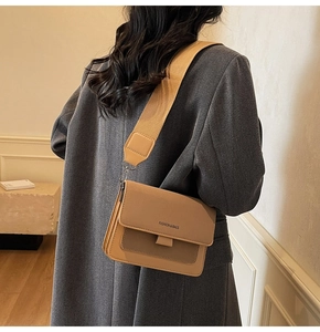Detail of crossbody square bag with wide shoulder strap and magnetic flap closure