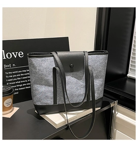Detail of color-block tote bag with grey felt texture and black faux leather strap accents