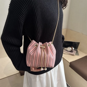 Pink and black tweed drawstring bucket bag with gold chain strap and pearl accents