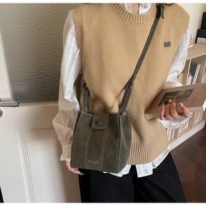 Detail of olive green vintage crossbody bucket bag featuring white contrast stitching