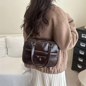 Retro dark brown glossy bowling bag with heart pendant and bow details shown on model