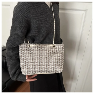 Brown and white tweed chain shoulder bag shown on model for size and style reference