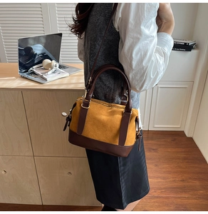 Gros plan d'un sac oreiller en daim jaune avec poignées en cuir marron sur table