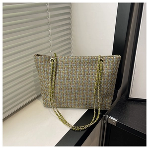 Close-up of pastel tweed woven tote bag with gold chain strap and textured grid pattern