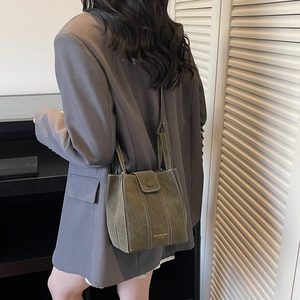 Vintage green suede shoulder bag with contrast white stitching and minimalist tote design