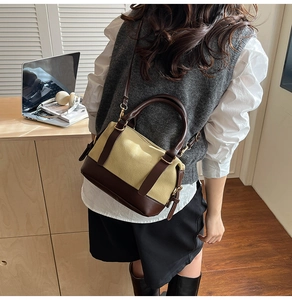 Detail of retro color-block handbag with canvas texture and brown leather accents