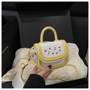 Detail of yellow and white cherry print mini bag inside a black gift box