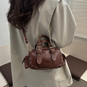 Retro dark brown mini Boston bag with oil-wax texture and rivets shown on model