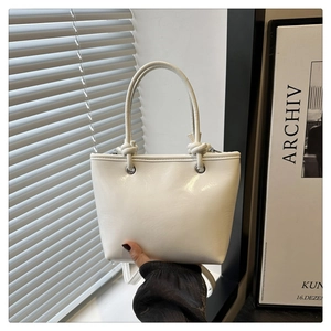 Vue détaillée du sac seau en cuir PU blanc avec poignée nouée et anneaux métalliques