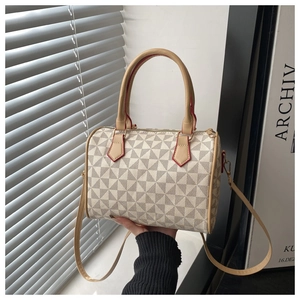Detail view of Boston handbag featuring geometric patterns and brown leather handles