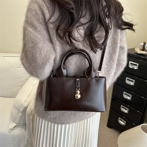 Deep brown patent leather square handbag with golden gourd pendant and dual strap design