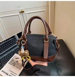 Détail du sac oreiller contrasté avec breloque ours et finitions métalliques dorées