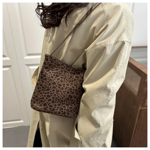 Detailed view of vintage leopard print bucket bag shown worn by a model in a studio