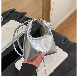 Detail of silver metallic trapezoid handbag with hollow handle and HYU7ZA branding