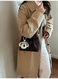 Détail du sac seau marron mat avec boucle de ceinture et adorable breloque en peluche