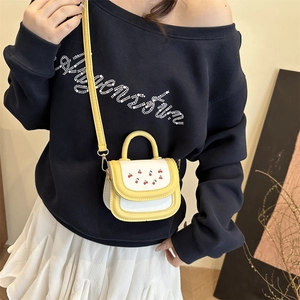 Minimalist yellow and white crossbody bag with cherry print shown on a model