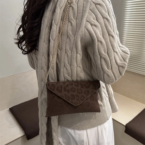 Sac bandoulière tendance imprimé léopard avec chaîne dorée porté par un mannequin