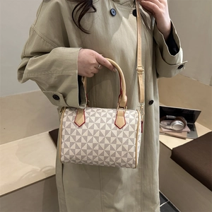 Chic Boston handbag with beige triangle patterns and brown leather strap on khaki coat