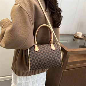 Modern Boston handbag with geometric pattern and beige strap in stylish home setting
